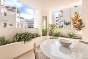 a white dining room with a white table and chairs at Jardines - Tabor 2 1 POOL VIEW 2B in Palm-Mar