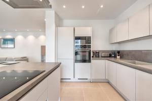 a white kitchen with white cabinets and appliances at Jardines - Tabor 2 1 POOL VIEW 2B in Palm-Mar