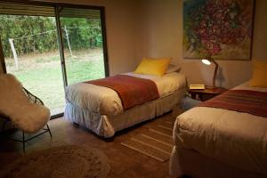 a bedroom with two beds and a window at Hare Paoa Lodge in Hanga Roa