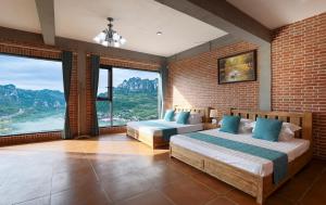 1 dormitorio con 2 camas y ventanas grandes en Yosemite Riverview Homestay, en Yichang