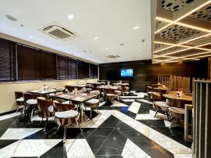 a restaurant with tables and chairs in a room at Morvee Hotels Alipore Kolkata in Kolkata