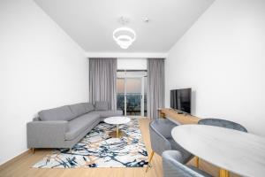 a living room with a couch and a table at ALH Vacay - Modern 2 Bedroom suitable for family in Dubai