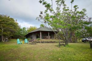 a house with two blue chairs in front of it at Hare Paoa Lodge in Hanga Roa