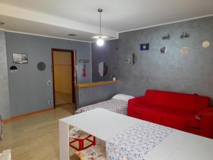 sala de estar con sofá rojo y cama en BIKE HOUSE 2 "evo", en Seriate