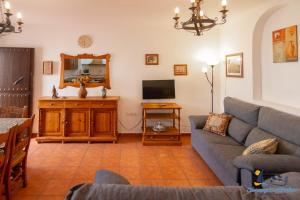 a living room with a couch and a tv at El Velero Sotillo Piscina Wifi Playa in San José
