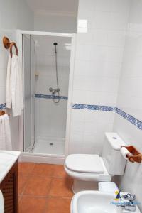 a white bathroom with a shower and a toilet at El Velero Sotillo con Piscina in San José