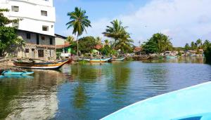 a boat traveling down a river with boats in it at st anns holiday home negombo in Negombo