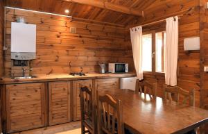 uma cozinha com uma longa mesa de madeira e cadeiras em El Llano de los Conejos Serranía de Cuenca em Cañamares
