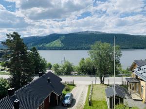 una casa con un coche aparcado frente a un lago en Åre Travel - Brygghusen, en Åre