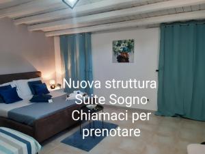 una camera d'albergo con letto e cuscini blu di Ettore Casa Vacanze a Comiso