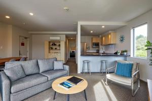a living room with a couch and a table and a kitchen at Waves on the Esplanade in Kaikoura