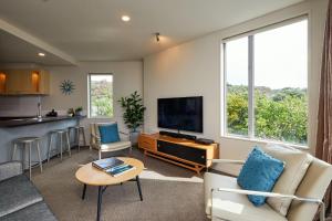 a living room with a couch and a tv at Waves on the Esplanade in Kaikoura