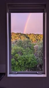 a view of a rainbow through a window at Waves on the Esplanade in Kaikoura +48 photos