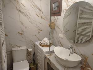 W łazience znajduje się umywalka, toaleta i lustro. w obiekcie The family's house w mieście Tríkala