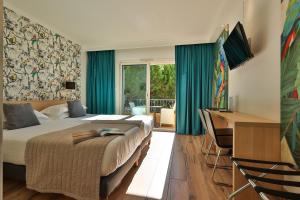 a hotel room with a bed and a desk and a desk at Le Petit Prince in Sainte-Maxime