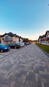 un aparcamiento con coches estacionados frente a las casas en Hotel Załęcze, en Pątnów