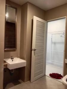 a bathroom with a sink and a shower backdoor at Baan Ampai Beach Hotel in Hua Thanon Beach
