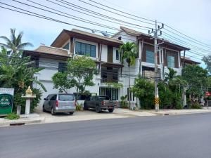 two cars parked in front of a house at Baan Ampai Beach Hotel in Hua Thanon Beach