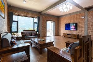 sala de estar con muebles y TV de pantalla plana. en Yosemite Riverview Homestay, en Yichang