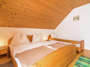 a bed in a room with a wooden ceiling at Beautiful Holiday Home in Weinebene with Sauna in Posch Alpe