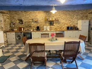 cocina con mesa y sillas en una habitación en Le gîte d'Arthur, en Guillac