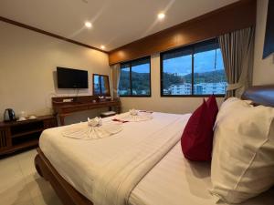 a bedroom with a large white bed with red pillows at Patong Heaven in Patong Beach