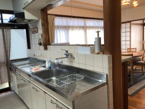 a kitchen with a stainless steel sink and a table at Guest house Nagi - Vacation STAY 21489v in Kanayama