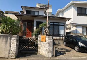 une maison avec une voiture garée devant elle dans l'établissement Guest house Nagi - Vacation STAY 21489v, à Kanayama