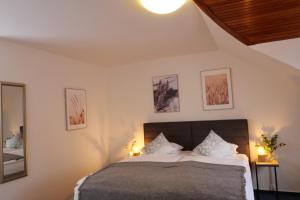 a bedroom with a bed with two lamps and two pictures at Hotel Baroko in Prague