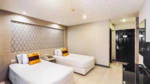 una camera d'albergo con due letti e un divano di C Hotel Bangna a Bangkok