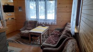 sala de estar con sofá, mesa y sillas en Domek Pod Smrekiem en Marcinkowice