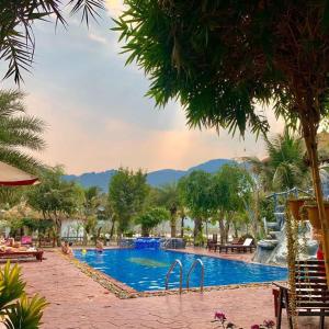 - une grande piscine avec des personnes séjournant dans un complexe dans l'établissement Vang Vieng Savanh Sunset View Resort, à Vang Vieng