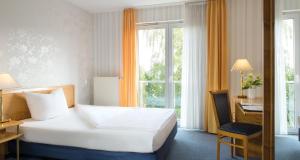 a hotel room with a bed and a window at Victor's Residenz-Hotel Gummersbach in Gummersbach