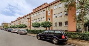 une rangée de voitures garées devant un bâtiment dans l'établissement HejU - Altbau meets Design - Parkplatz - Netflix, à Lübeck