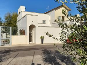 ein weißes Haus mit einem Tor und Blumen in der Unterkunft CASA MONTEFINESE in Casamassima