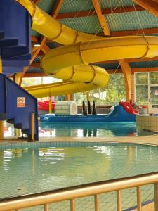 a swimming pool with a slide in a building at Willow View - Hoburne Cotswolds Holiday Park in South Cerney