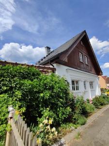 uma pequena casa branca com um telhado castanho em Dům na návsi em Teplice