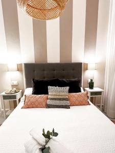 een slaapkamer met een groot bed en een gestreepte muur bij Spalis Suite Loft de lujo en el centro histórico in Sevilla