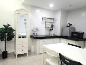 コタバルにあるTapeer Homestay 19CC188 @D Perdana Kota Bharuのキッチン(白いキャビネット、白いテーブル、椅子付)