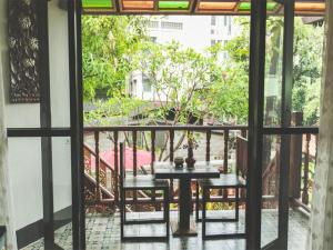 een patio met een tafel en stoelen op een balkon bij Hetai Boutique House in Chiang Mai