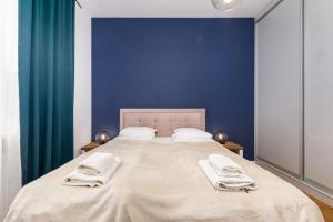Jurajska 4 by Homeprime في وارسو: غرفة نوم بسرير كبير بجدران زرقاء