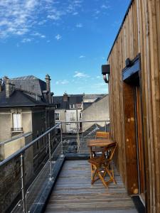 a wooden deck with a table and a chair on a balcony at 9WAGRAM Hotel Boutique in Le Mans