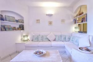 uma sala de estar branca com um sofá branco e uma mesa em Costa Corallina Villa con spiaggia sotto casa e vista meravigliosa em Costa Corallina