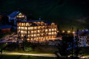 un grande edificio con luci accese di notte di Hotel Alcialc a La Valle