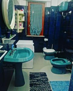 a bathroom with two toilets and a green sink at Il Quadrifoglio di Triveri in Bovalino Marina