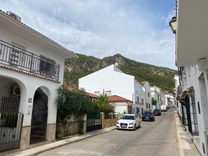 une voiture blanche garée dans une rue avec une montagne dans l'établissement Casa Feria, à Algodonales