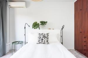 a bedroom with a white bed with a black and white pillow at Home2Book Stylish Apartment Caletillas in Candelaria