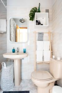 a bathroom with a toilet and a sink and a mirror at Home2Book Stylish Apartment Caletillas in Candelaria