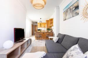 a living room with a couch and a tv at Home2Book Stylish Apartment Caletillas in Candelaria