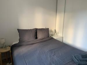 um quarto com uma cama grande e um cobertor azul em Appartement Design I - Port du Rosmeur - Douarnenez em Douarnenez